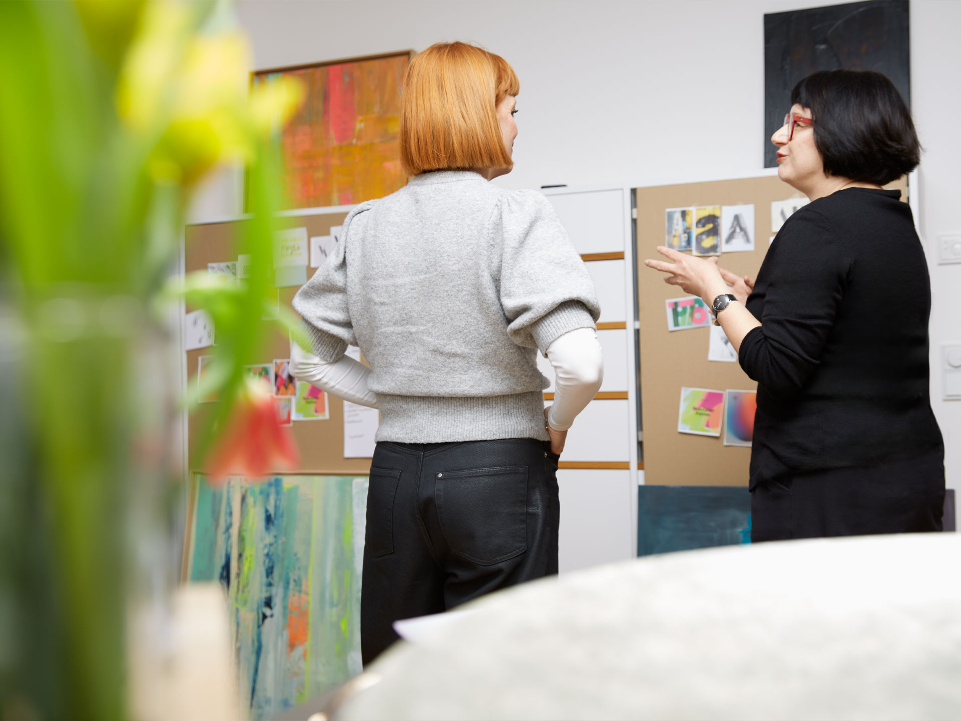 5-workshop-gespraech-vor-Pinwand Teilnehmerin und ich stehen vor der Workshop-Pinwand und besprechen ihre aufgehängten Materialien