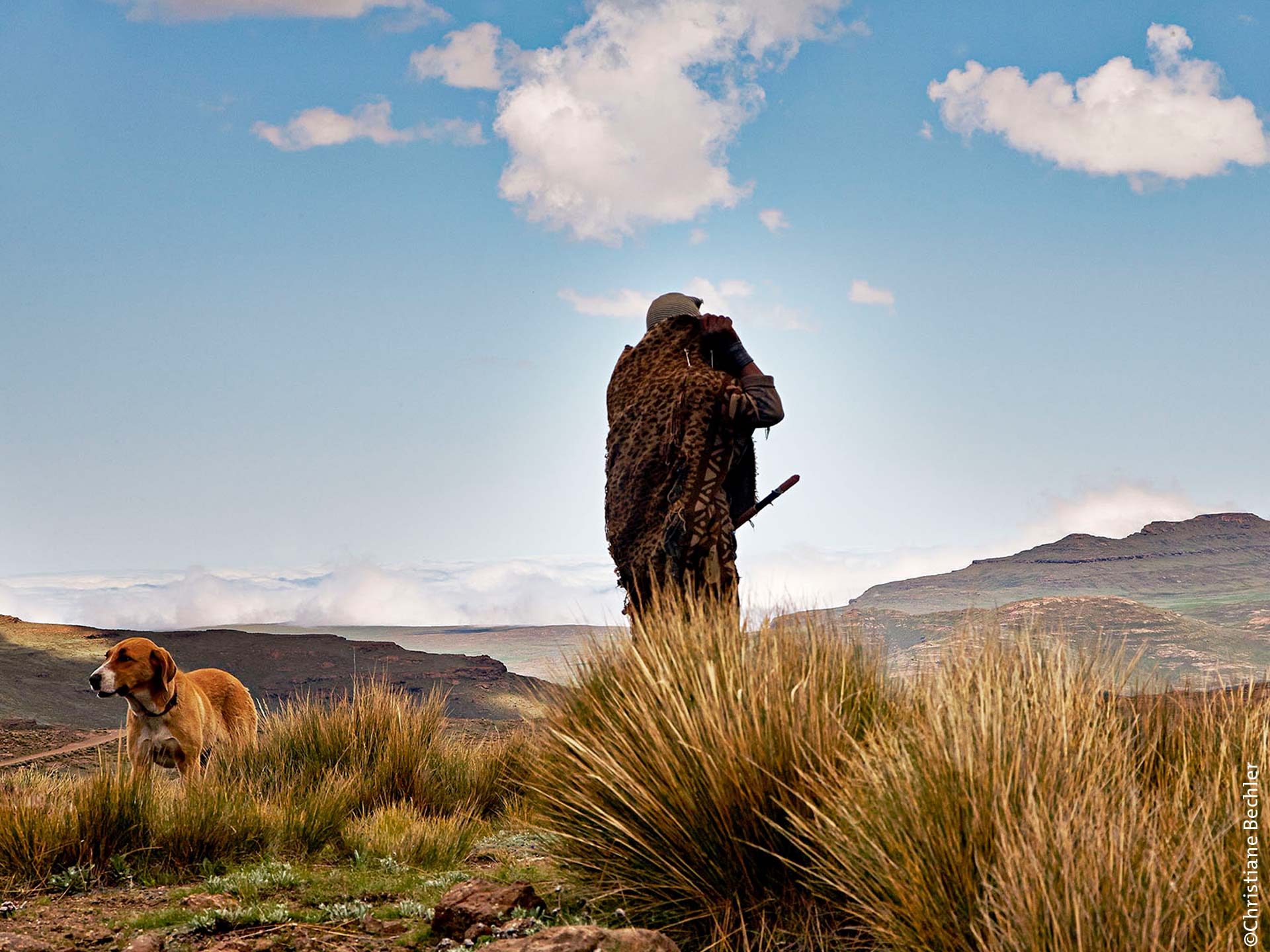 Bildinterpretation Hirte zieht sich gegen den kalten Wind seine Decke vors Gesicht in den Drakensbergen, Lesotho.